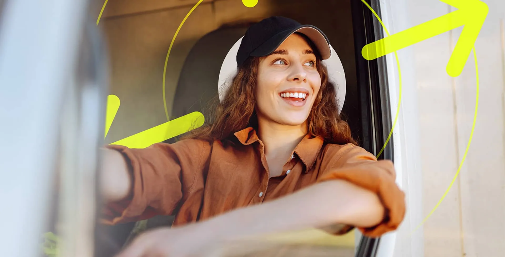 A young female delivery driver in a cap looking out of her van window to speak with someone.